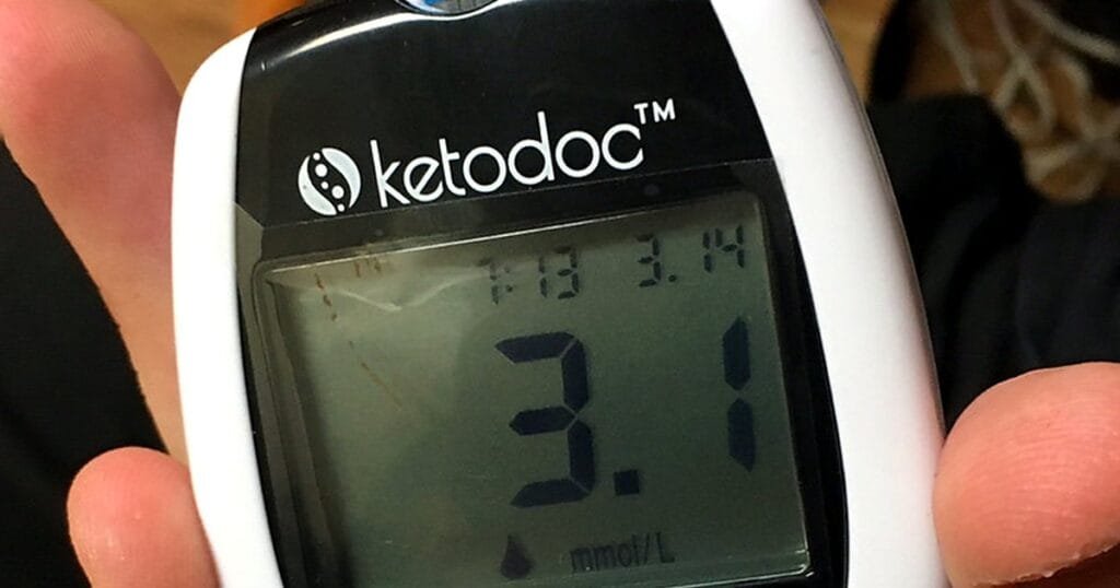 A close-up of a handheld ketone meter displaying a reading of 3.1 mmol/L.