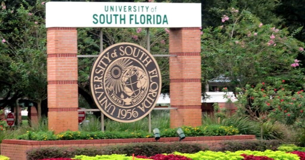 Sign for the University of South Florida with flowers in the foreground.